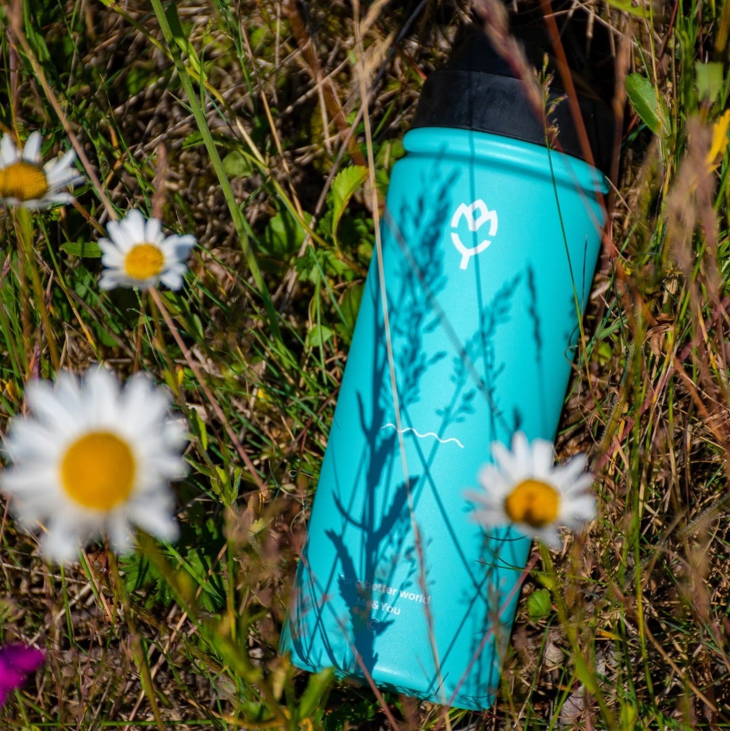 Detská termoska so slamkou 500ML (modrá) ležiaca v tráve, zvýraznená krása a dizajn fľaše