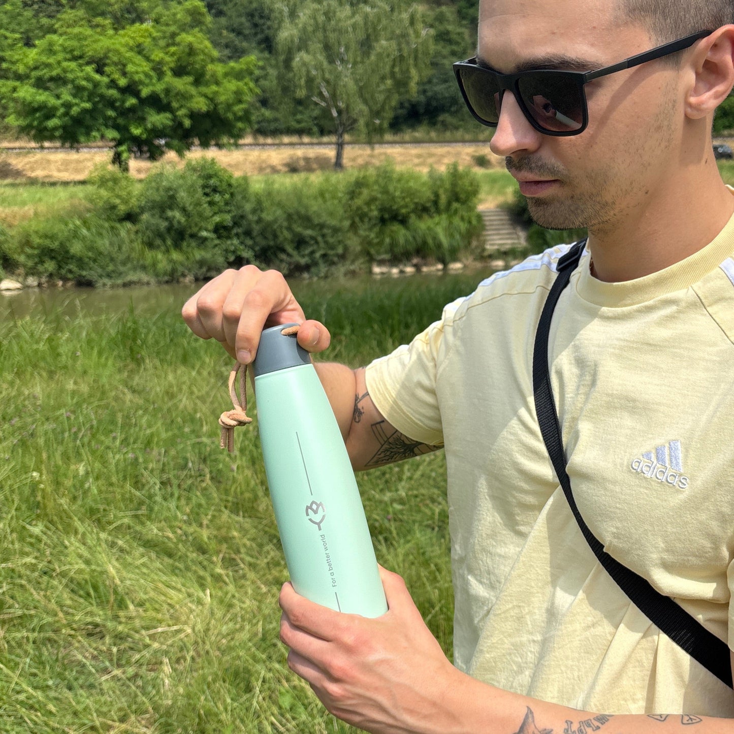 Muž drží termosku Mist – pripravuje sa otvoriť viečko, detailný pohľad na dizajn