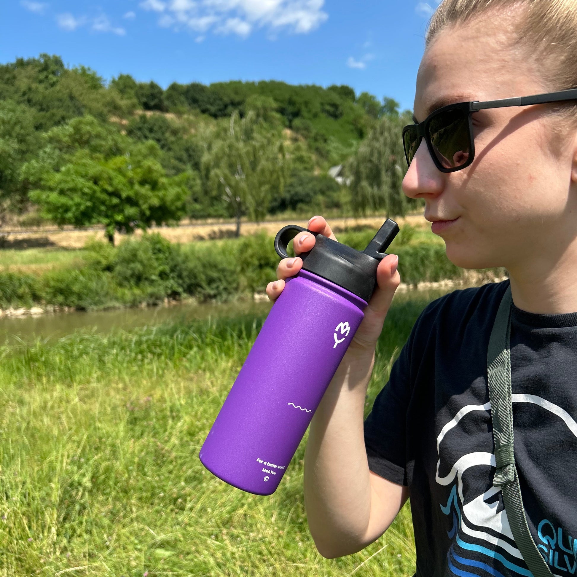 Žena drží termofľašu Gloxie pri tvári s otvoreným viečkom so slamkou, pripravená sa napiť – ukážka funkčného uzáveru so slamkou.