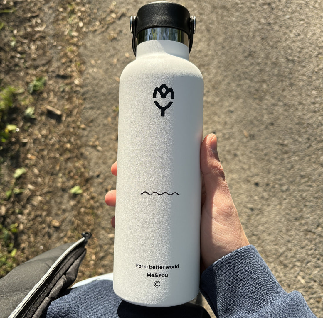 Termoska na vodu Beluga 750ML držaná v ruke, zvýraznený dizajn a farba fľaše, v pozadí les

